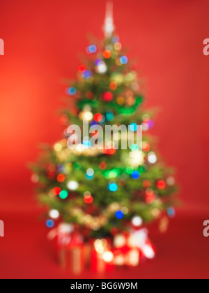 Out of focus decorated Christmas tree isolated on red background Stock Photo