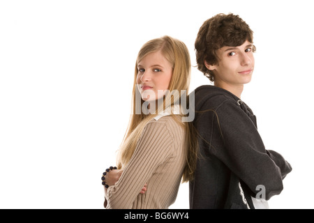Teenage couple standing back to back with arms crossed isolated on white background Stock Photo