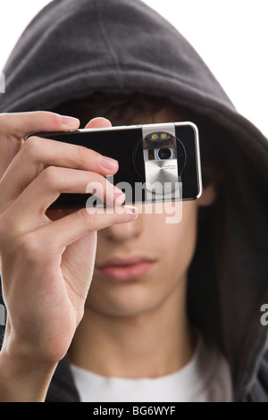 Close-up portrait of young man wearing hooded sweatshirt taking a picture using phone camera Stock Photo