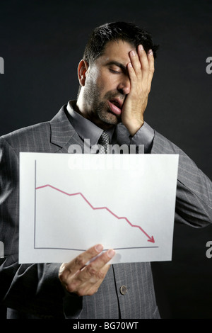 Businessman with bad sales reports chart. Crisis Stock Photo