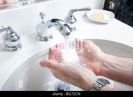 close up of hands being washed with soap in bathroom sink Stock Photo
