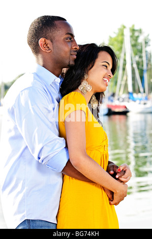 Young romantic couple hugging and standing at harbor in profile Stock Photo