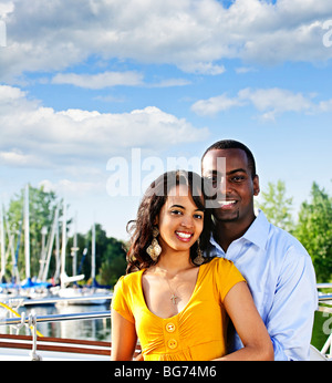 Portrait of young romantic couple standing at harbor with copyspace Stock Photo