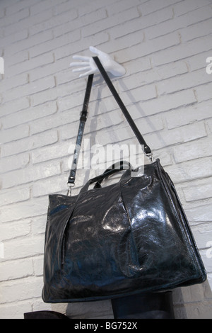 womans leather shoulder bag hanging on wall in shop Stock Photo