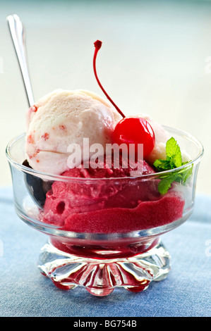 Dish of ice cream with cherry on top and spoon Stock Photo
