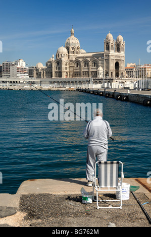 Man Fishing in Front of Marseille Cathedral or Cathédrale de la Major (1852), La Joliette, Marseille Docks, Marseille, Provence, Franc Stock Photo