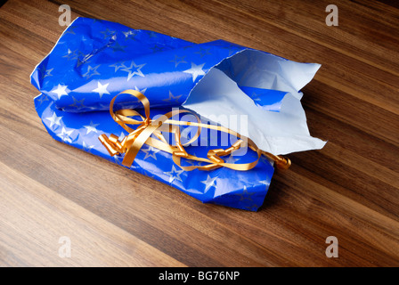 Torn gift wrapping on floor Stock Photo