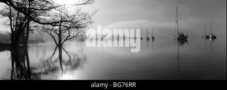 Reflections of trees and boats on Windermere in Cumbria. Stock Photo