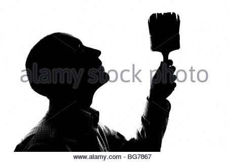 Silhouetted man painting indoors Stock Photo