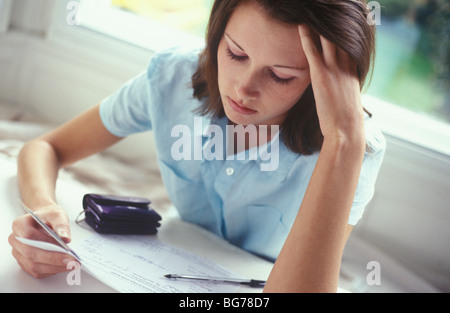 young woman with credit cards looking worried Stock Photo