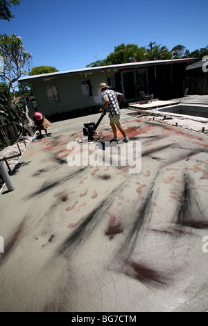 Spreading ochre on freshly laid concrete adds color to the surface. Stock Photo