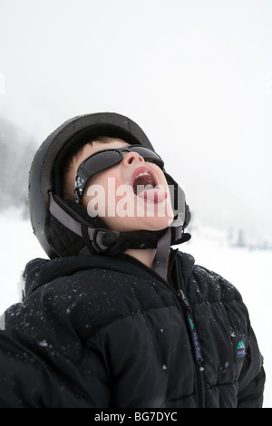 a young boy catching snowflakes on tongue Stock Photo