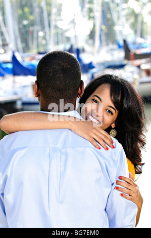 Beautiful young woman hugging boyfriend standing at harbor Stock Photo