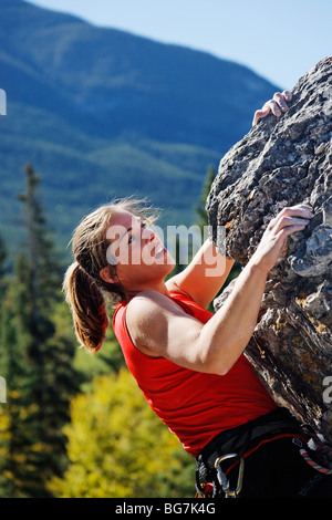 Female climber climbing overhanging rock face, Banff, Banff National Park, Alberta, Canada Stock Photo