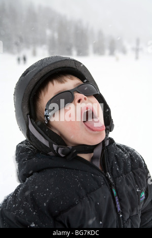 a young boy catching snowflakes on tongue Stock Photo