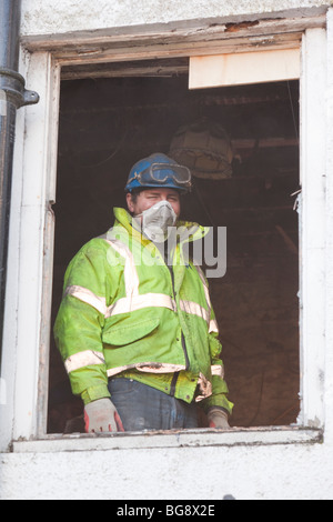 A workman working on a flood damaged house in Cockermouth Stock Photo