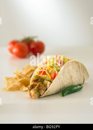 Grilled chicken taco on white with tortilla chips and tomatoes Stock Photo