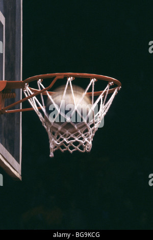 Basketball going through a hoop Stock Photo