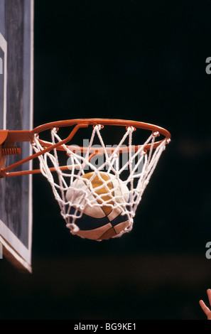 Basketball going through a hoop Stock Photo