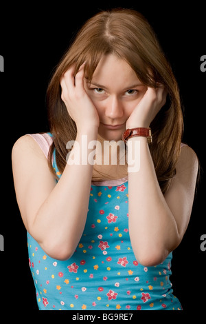 angry girl keeps hands on her head, over black Stock Photo