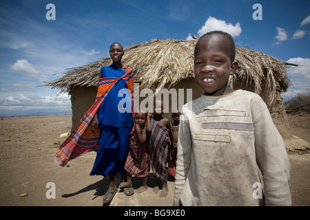 A Maasai family stands in front of their house in village of Tindagani, Kilimanjaro Region, Tanzania, East Africa. Stock Photo