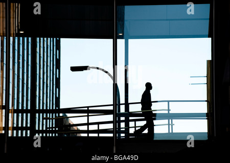 Businessman walking to work through elevated walkway Stock Photo