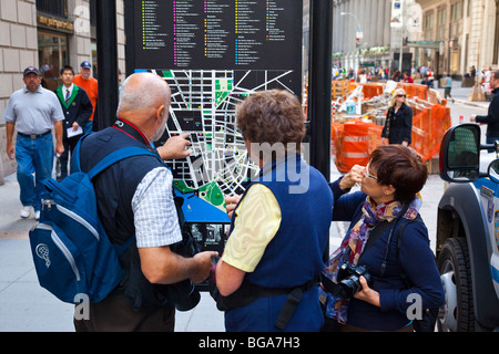 European tourists finding their way with a map in downtown Manhattan, New York City Stock Photo