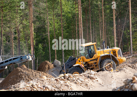 Front loader moving sand in a sandpit  at sand quarrying area, Finland Stock Photo