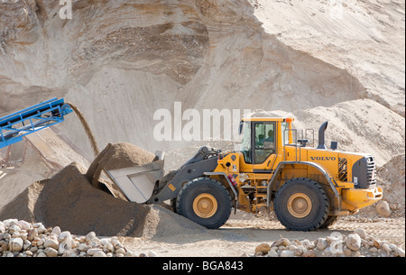 Volvo front loader loading sand in a sandpit at sand quarrying area , Finland Stock Photo