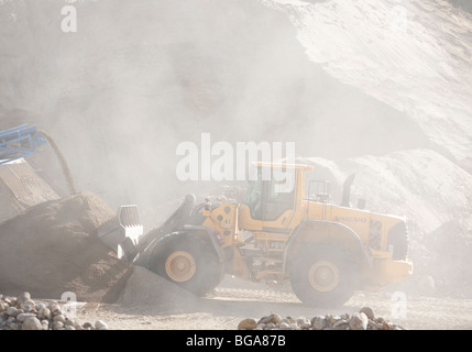 Front loader moving sand and grit in a sandpit at sand quarrying area , Finland Stock Photo