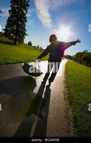 Woman playing in the rain puddles Stock Photo