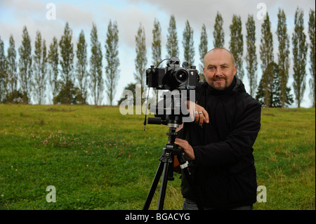 Landscape photographer Tony Wainwright with a 6x17 panoramic camera on tripod working in East Sussex fields. Stock Photo