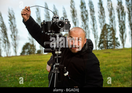 Landscape photographer Tony Wainwright with a 6x17 panoramic camera on tripod working in East Sussex fields. Stock Photo