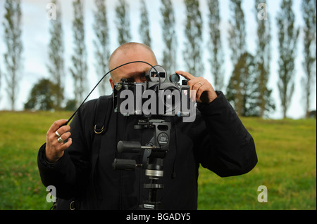 Landscape photographer Tony Wainwright with a 6x17 panoramic camera on tripod working in East Sussex fields. Stock Photo