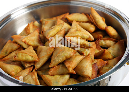 A serving bowl full of fresh vegetable samosas, a popular snack or starter in Arabia and South Asia Stock Photo