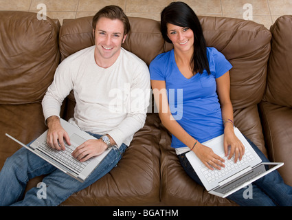 Young couple relax at home with a laptop. Stock Photo