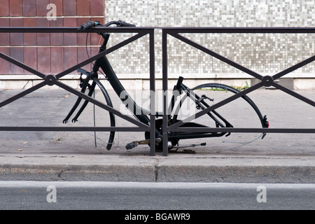A cycle with missing wheels next to a road railing View from the side. Close up Stock Photo