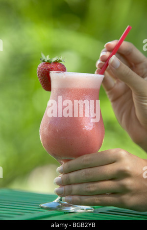 Female hands holding a strawberry daiquiri cocktail Stock Photo