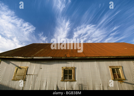 Low angle view of old storage shed and clouds, St. Paul, Oregon Stock Photo