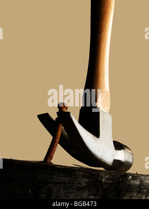 Hammer Removing A Nail From A Wooden Surface Stock Photo