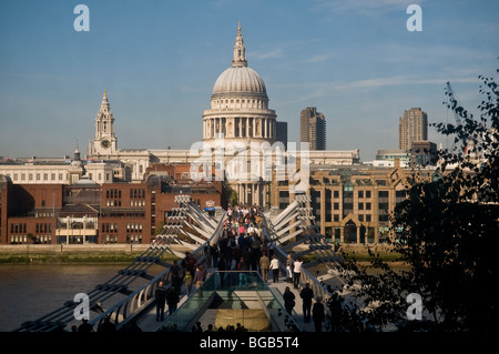 People on the Millennium Bridge crossing the River Thames, London, UK with view of Saint Paul's Cathedral from Tate Modern Stock Photo