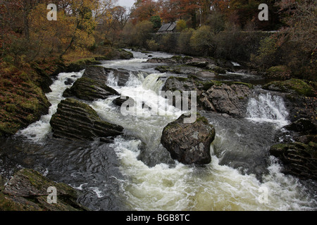 The turbulent Afon Llugwy flows through the village of Capel Curig, Snowdonia, North Wales Stock Photo