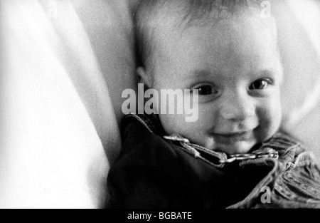 Photograph of girl daughter baby black white grainy smile bed UK Stock Photo