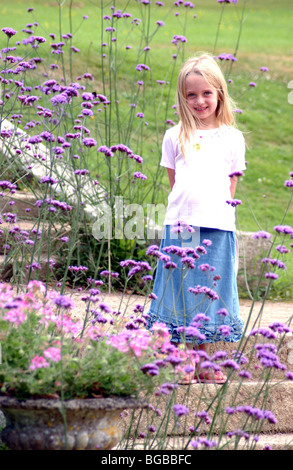 Royalty free photograph of young girl portrait as she stands in sunshine in family garden London UK Stock Photo