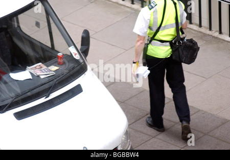 Royalty free photograph showing female traffic warden checking parking ticket in London UK Stock Photo