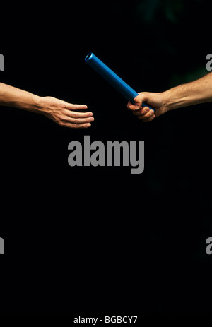 Two athletes passing a baton Stock Photo