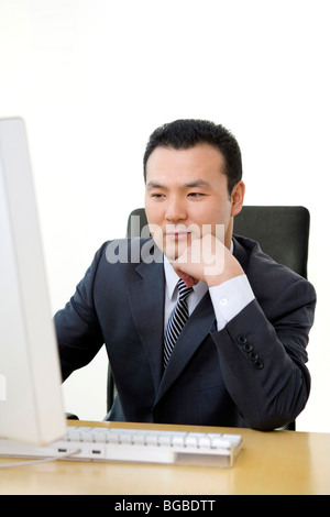 Man uses computer in a well-lit, sunny office Stock Photo