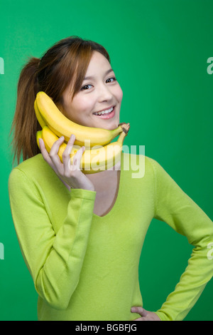 Woman in green with bananas Stock Photo