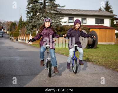 Two girls, nine years, unicycling Stock Photo