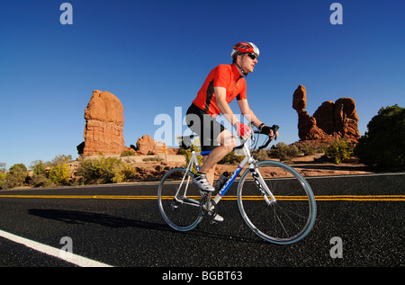 Race cyclist, Balanced Rock, Arches National Park, Moab, Utah, USA